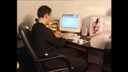 Ein junger Mann vor einem Computer  