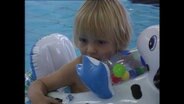 Kind mit Schwimmring im Pool  