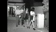 Polizisten begleiten Prostituierte aus einem illegalen Bordell  