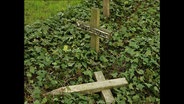 Ein umgestürztes Friedhofskreuz  