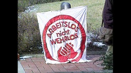 Banner mit der Aufschrift "Arbeitslos nicht wehrlos"  