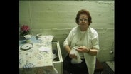 Eine sog. Toilettenfrau mit einem Teller für Trinkgeld  