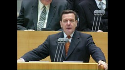 Gerhard Schröder an einem Rednerpult  
