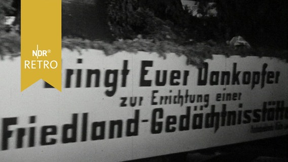 LKW, auf dem die geschmückte "Friedlandglocke" geladen ist, mit dem Slogan "Bringt Euer Dankopfer zur Errichtung einer Friedland-Gedächtnisstätte" (1964)  