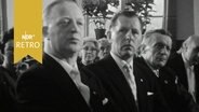 Mehrere Männer in Anzügen in der ersten Reihe beim Festakt zum 100-jährigen Bestehen des Männergesangsvereins Leck (1964)  