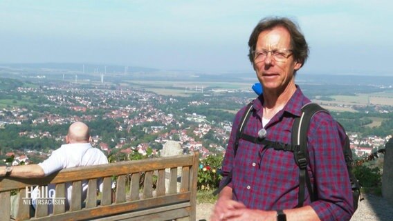 Thomas Stumpf steht am Rand der Aussichtsplattform vom Burgberg und gibt ein Interview.  