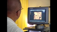 Ein Arzt schaut auf ein Ultraschall-Gerät  