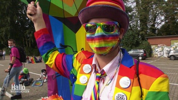 Ein Besucher des CSD in Oldenburg komplett in Regenbogenfarben gekleidet.  