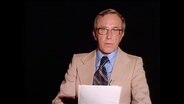 Ein Moderator spricht in die Kamera  