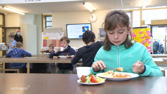 Ein Mädchen isst in der internationalen Schule in Schwerin ihr Mittagessen.  
