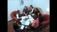 Sieben Frauen sitzen an einem Tisch  