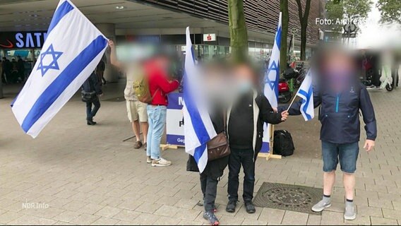 Teilnehmer einer Mahnwache für Israel und gegen Antisemitismus.  