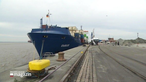 Der Containerfrachter "Elbblue" liegt an der Kaimauer.  