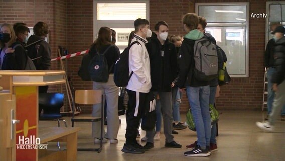 Archiv: Schüler stehen mit Maske in einem Kreis und unterhalten sich.  