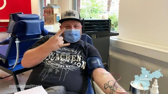 Ein Metal-Fan mit Wacken-T-Shirt spendet Blut im UKE.  