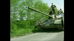 Männer fahren auf einem Panzer  