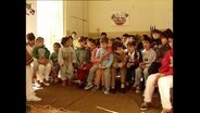Kinder haben sich in einem Raum versammelt  