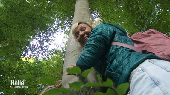 Christina von Saß umarmt einen Baum.  