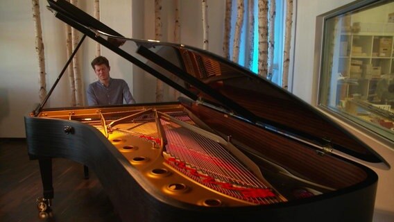 Ausnahmepianist Alexander Krichel sitzt an einem Flügel.  