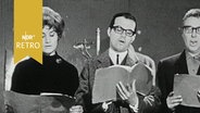 Zwei Schauspieler und eine Schauspielerin lesen aus dem Skript bei einer Theaterprobe (1965)  