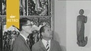 Zwei Besucher im Gespräch über eine Statue auf Schloss Gottorf (1963)  