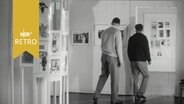 Besucher in einer Ausstellung von Karikaturen Rudolf Wilkes in Hannover (1964)  