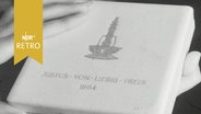 Hände halten eine Schatulle mit der Aufschrift "Justus-von-Liebig-Preis 1964"  