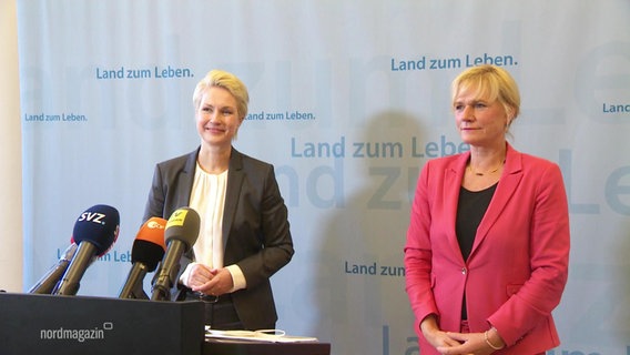 Die Ministerpräsidentin Manuela Schwesig und Simone Oldenburg bei einer Pressekonferenz vor Mikros.  