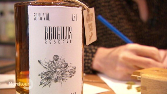 Eine Flasche Gin der Marke Brogilus steht auf einem Tisch.  