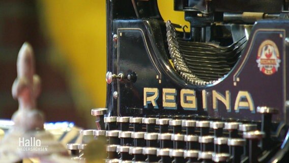 Eine alte Schreibmaschine der Marke Regina steht auf einem Tisch.  