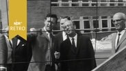Mehrere Rundfunkräte lassen sich von einem anderen Mann auf einer Baustelle etwas erklären (1964)  