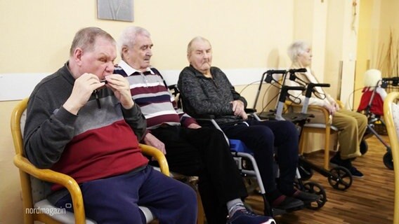 Alte Menschen sitzen nebeneinander und warten.  