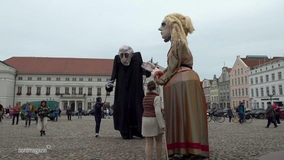 Auf dem Marktplatz von Wismar stehen drei Meter große Puppen. Eine von ihnen ist der Vampir Nosferatu.  