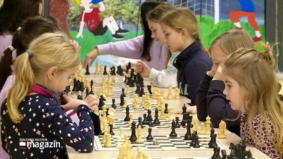 Junge Mädchen spielen gemeinsam Schach.  