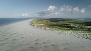 Eine nordfriesische Insel aus der Vogelperspektive, im Bildvordergrund ein breiter Sandstrand.  