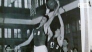 Ein frühes Bild von Hermann Huß, der einen Basketball in den Korb hievt.  