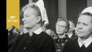 Zwei Krankenschwestern mit Häubchen und Ordenstracht im Publikum einer Festveranstaltung (1964)  