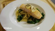 A plate of spaghetti with salmon.  