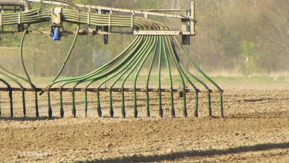 Düngemittel wird auf einem Feld verteilt.  