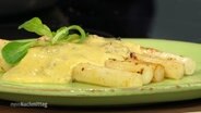 Black salsify is served on the plate with cranberry hollandaise.  