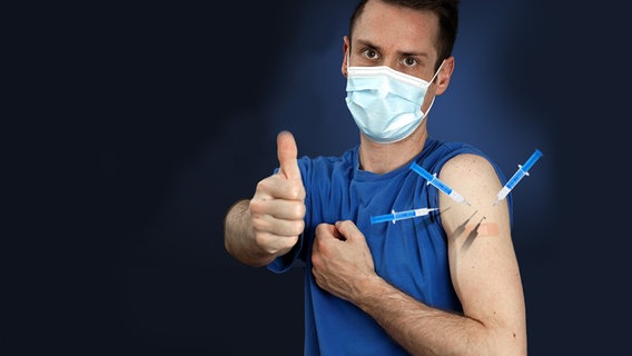 Mann mit Mundschutz und drei Nadeln im Arm.  