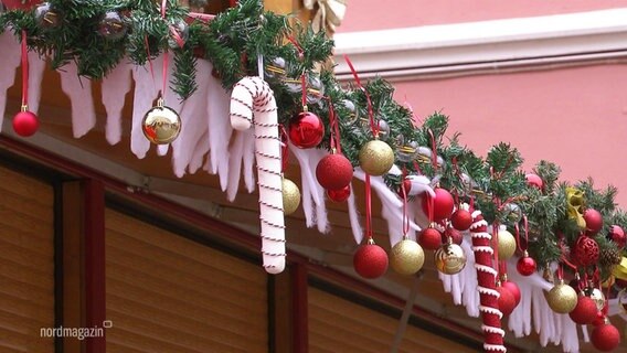 Dekoration hängt vom Dach eines Standes auf dem Weihnachtsmarkt.  