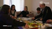 Eine syrische Familie wird von einer ehrenamtlichen Mitarbeiterin des Kinderschutzbundes im Alltag unterstützt. Hier eine Szene eines gemeinsamen Essens.  