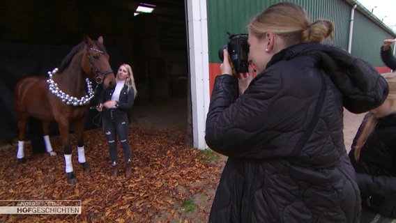 Eine Fotografin fotografiert ein Pferd und eine junge Frau.  