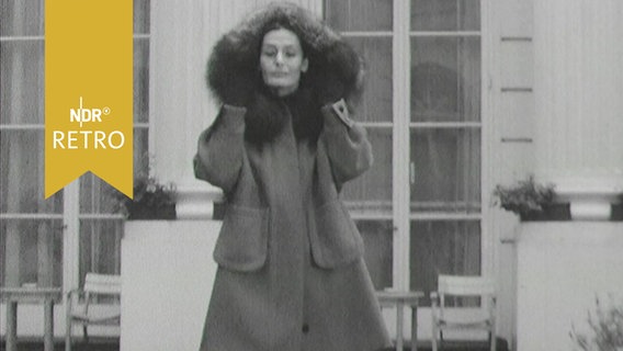 Mannequin im Wintermantel bei einer Modenschau 1963 vor  