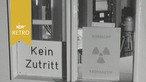 Schilder an der Glastür zu einem Labor: "Kein Zutritt" - "Vorsicht Radioaktiv" (1963)  