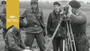 Drei Soldaten stehen um einen Topographen herum, ein sitzender Soldat protokolliert (1963)  