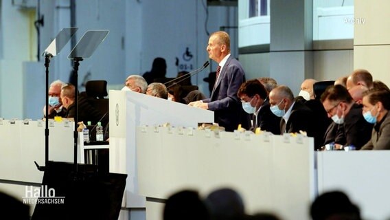 Männer, die zum Vorstand von VW gehören, auf einer Bühne. © Screenshot 