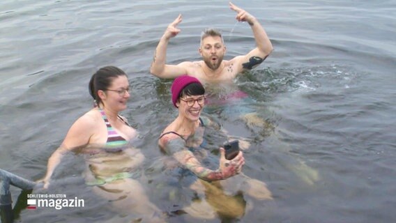 Iris Meschke, Philipp Jeß und eine weitere Schwimmerin machen ein Selfie im eiskalten Wasser. © Screenshot 