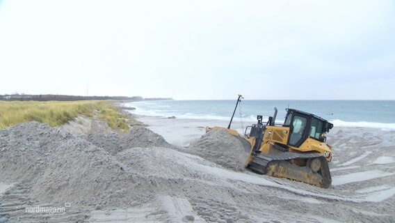 Eine Raupenbagger verteilt Sand an der Küste von Ahrenshoop. © Screenshot 